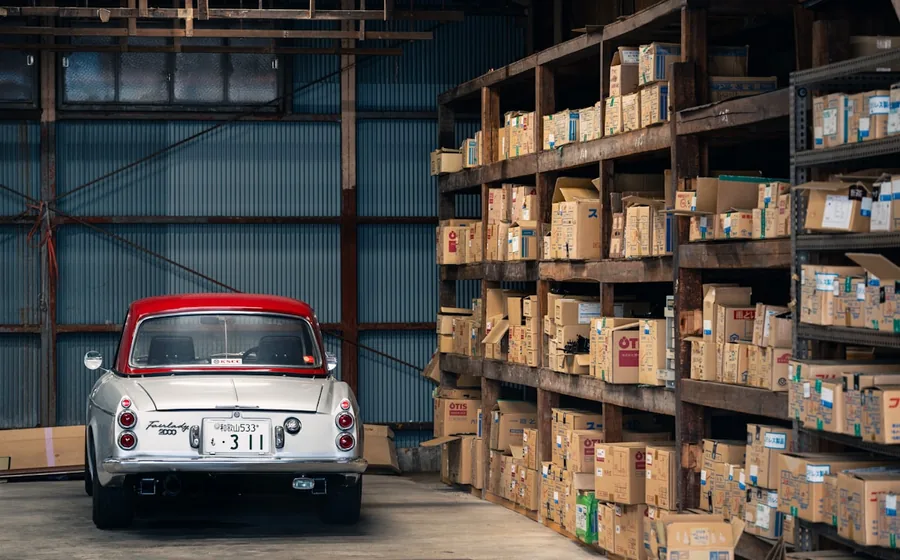 Shelves of boxed components lining the aisles of an automotive and industrial parts warehouse